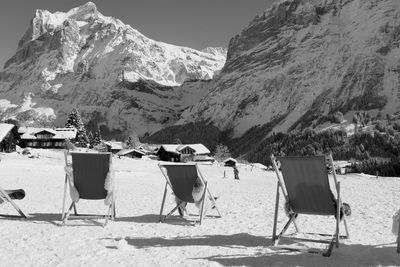 Chairs on beach against mountains