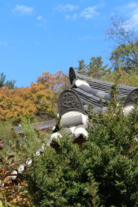 Statue amidst trees against sky