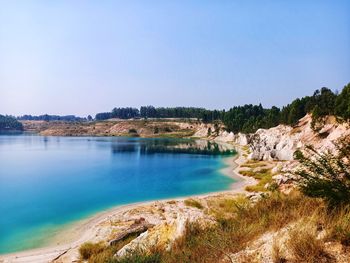 Scenic view of lake against clear blue sky