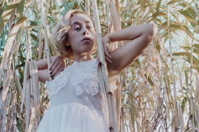 Young woman against trees on field