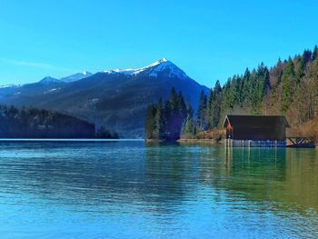 Scenic view of lake and mountains against blue sky