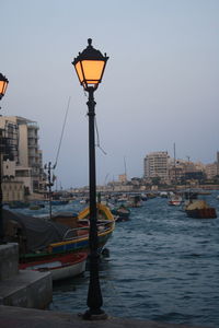 Canal in city against clear sky