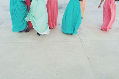Low section of women in colorful long skirts