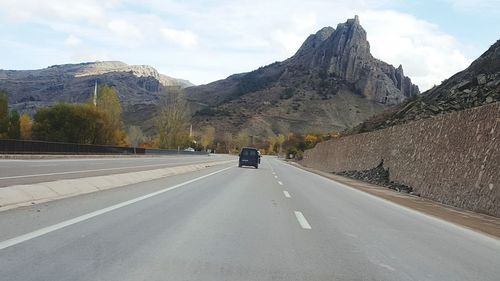 Cars on road against mountain range