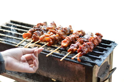 Close-up of person preparing food on barbecue grill