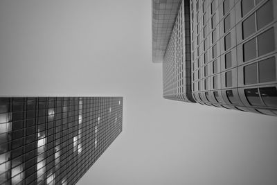 Directly below of modern buildings against clear sky during foggy weather