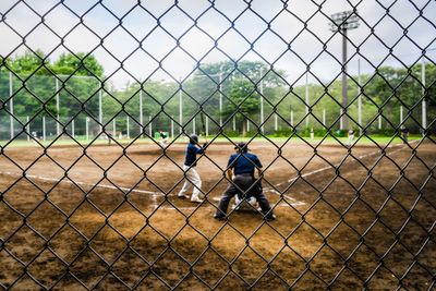 People playing seen through chainlink fence