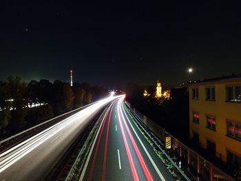 Light trails on road against sky at night