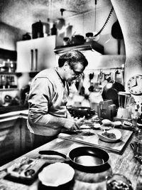 Side view of man preparing food in restaurant