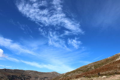 Low angle view of mountain against blue sky