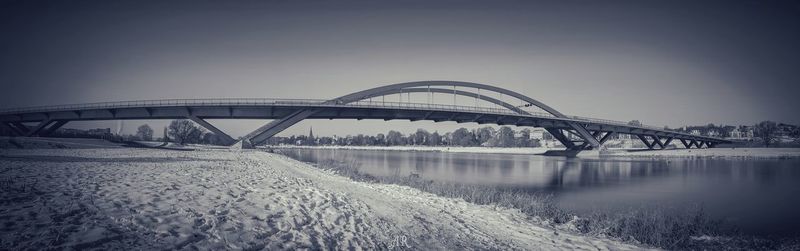 Bridge over river against sky during winter