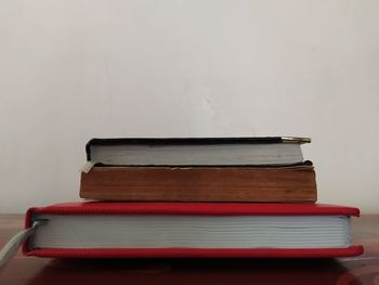 Close-up of books against wall on table