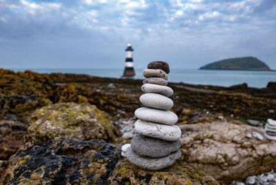 Stack of stones on beach against sky