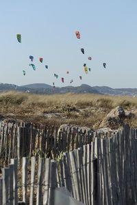 Parachutes over land against sky