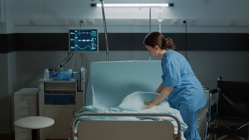 Side view of woman standing on bed