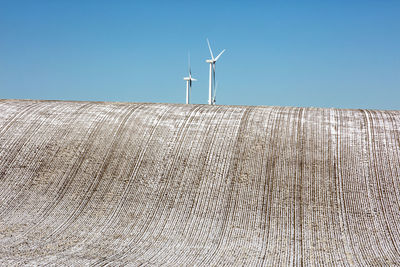 Wind turbines in a field with clear sky