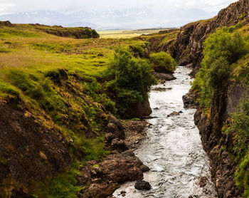 Scenic view of waterfall against sky