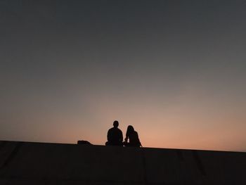 Silhouette couple against sky during sunset