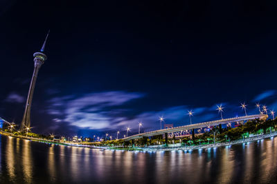 Illuminated bridge over river against sky at night