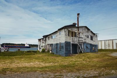 Abandoned house on field against sky