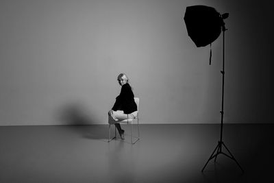 Full length of young woman sitting on a chair