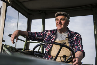 Portrait of smiling farmer on tractor