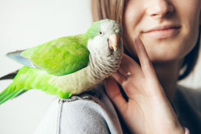 Close-up of woman with parrot on shoulder