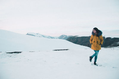 Rear view of woman standing on snow covered landscape