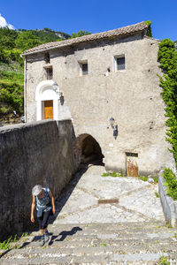 Man leaning on old building