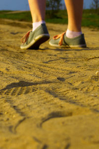 Low section of woman walking on ground