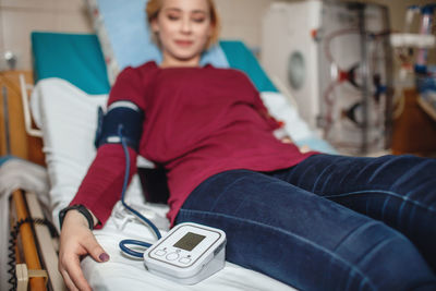 Young girl, monitored by dialysis system equipment during hemodialysis in hospital, habitual routine 