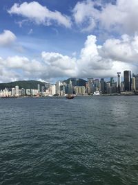 Sea by buildings against sky in city