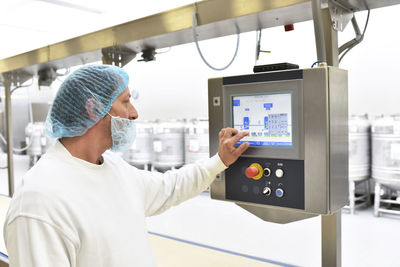 Worker operating machine in an industrial bakery