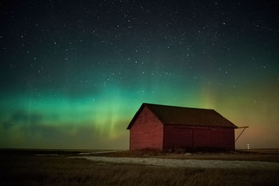 House on field against sky at night