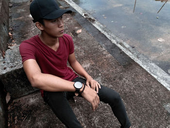 High angle view of young thoughtful man sitting on steps