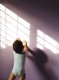 Boy standing against wall 