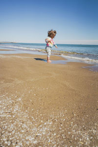 Rear view of woman standing at beach