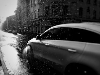Close-up of wet car on road during rainy season