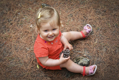 Little girl holding a cone in the woods forest