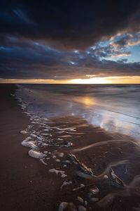 Scenic view of beach against sky during sunset