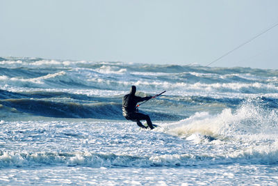 Man surfing in sea against clear sky