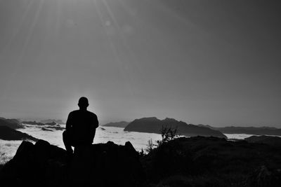 Silhouette man overlooking calm sea