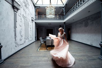 Woman with arms raised standing on floor