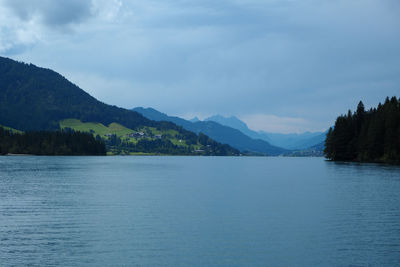 Scenic view of lake by mountains against sky