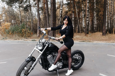 Portrait of woman riding motorcycle on road