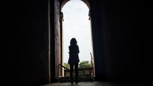 Rear view of woman looking at archway