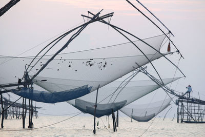 View of fishing nets at beach against sky