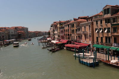 Boats moored at canal against buildings in city