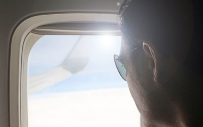 Close-up of man looking through window