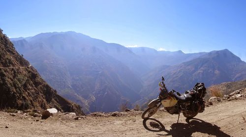 Horse riding motorcycle on mountains against clear sky